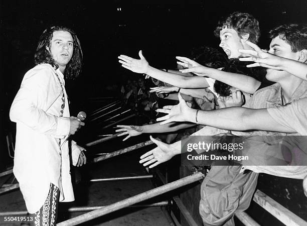 Singer Michael Hutchence, with the band INXS, watching crowds reach out to touch him as he performs at Wembley Stadium, London, June 30th 1988.