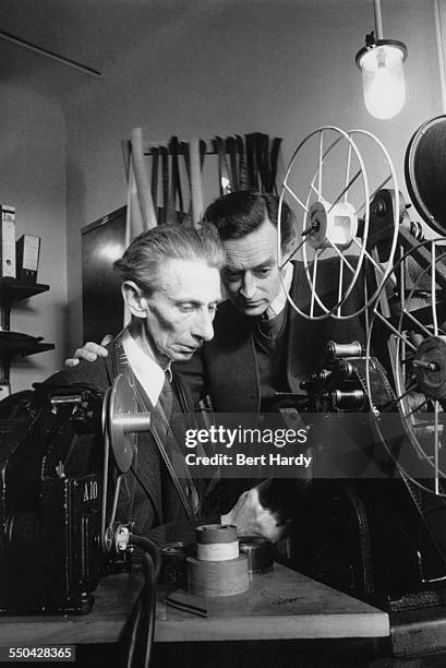 English film director David Lean working with a film editor during production of his film adaptation of 'Oliver Twist', Pinewood Studios,...
