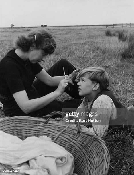 Hairdresser Helen Penfold with child actor Anthony Wager during location filming for director David Lean's film adaptation of Dickens' novel 'Great...