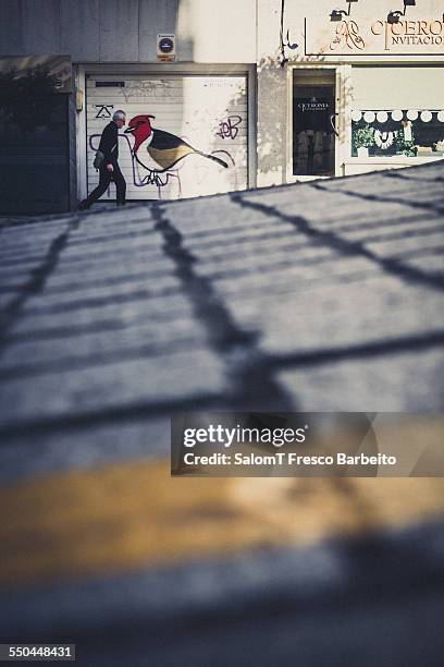 Man walking in the street in front a grafiti, Vigo, Spain