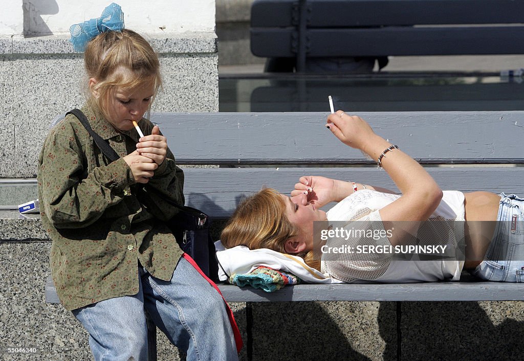 A girl and her mother smoke cigarettes o