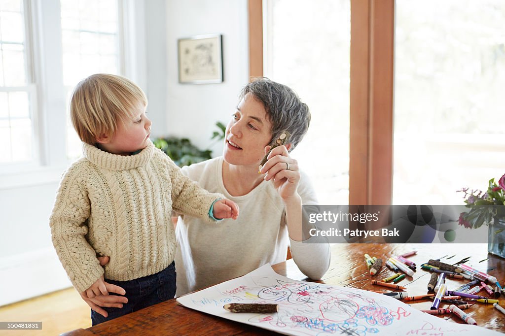 Lesbian mom draws w/ her daughter in dining room