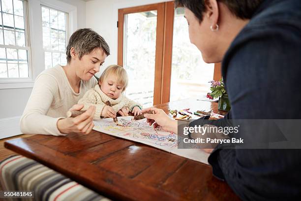 lesbian moms draw with their daughter at home - leaninlgbt stock pictures, royalty-free photos & images