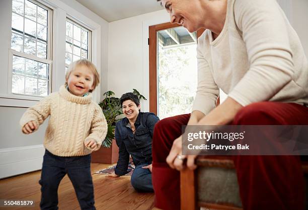 lesbian moms watch their daughter dance at home - leaninlgbt stock pictures, royalty-free photos & images