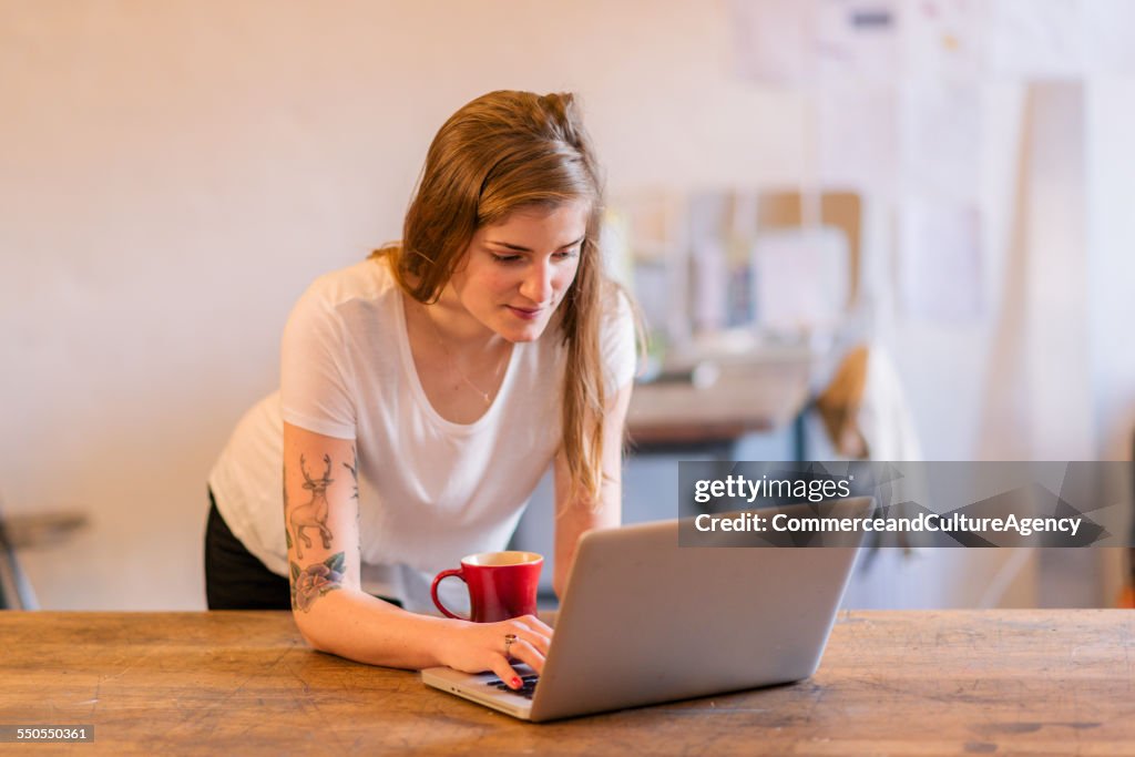 Craftswoman in studio working on laptop