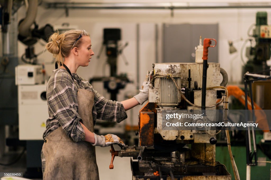 Young craftswoman using drill machine