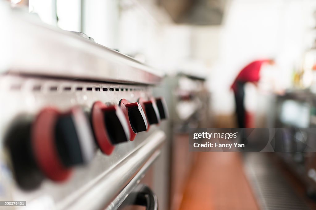 Oven in restaurant with a blurred cook behind