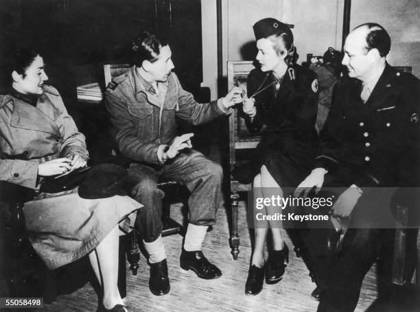 During her wartime service as a Red Cross nurse, British actress Madeleine Carroll shows off her dog tags to journalists at a press conference in...