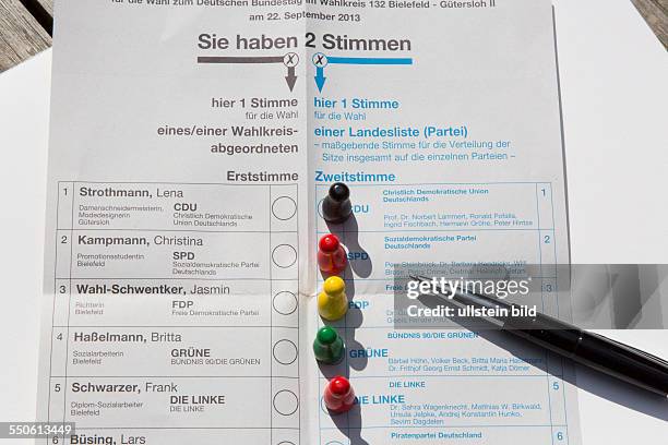 Spielfiguren in den Farben der politischen Parteien auf dem Wahlschein zur Bundestagswahl