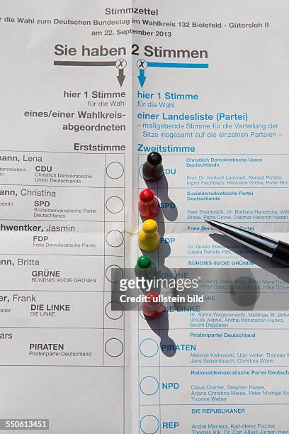 Spielfiguren in den Farben der politischen Parteien auf dem Wahlschein zur Bundestagswahl