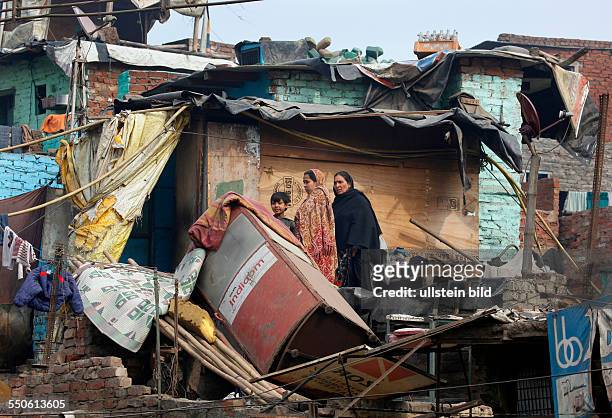 Neu Delhi, Indien, 15.01.10 - Heruntergekommenes Wohnviertel, zwei Frauen mit Kind in einem verwahrlosten zerstoerten Haus.