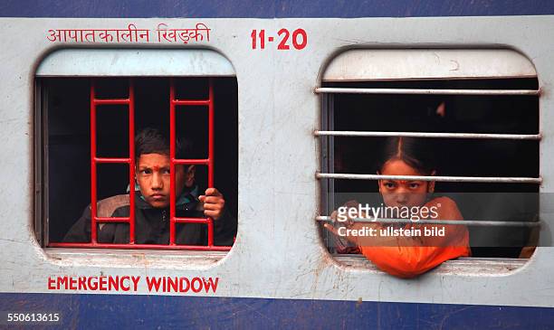 Neu Delhi, Indien, 15.01.10 - Bahnhof Neu-Dehli,ein Junge und ein Maedchen schauen aus einem Zugfenster.