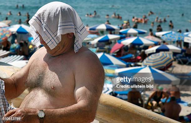 Benidorm,ESP, 28.08.09 - Sonnenschutz - mit einem Tuch auf dem Kopf schuetzt sich ein Mann vor der Sonne.