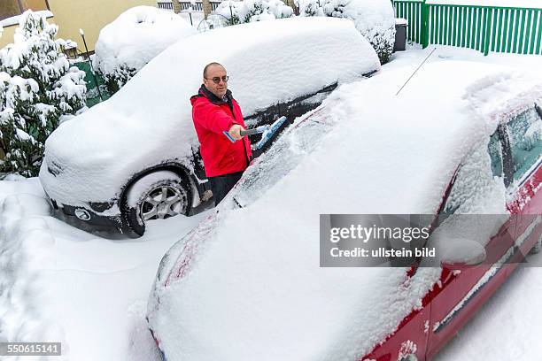 Schnee wird von einem Auto weg geschaufelt. Schneeräumung im Winter News  Photo - Getty Images