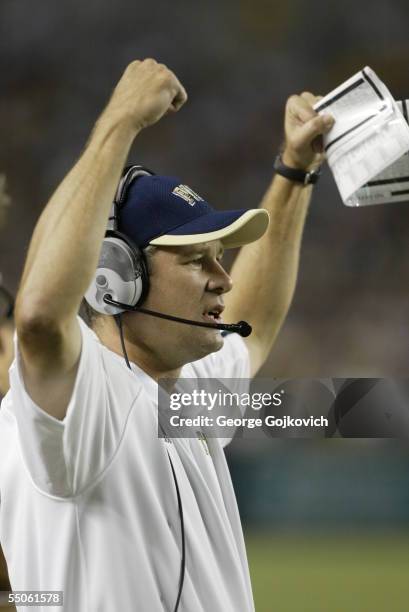 Defensive coordinator Paul Rhoads of the University of Pittsburgh Panthers signals to players on the field during a game against the Notre Dame...