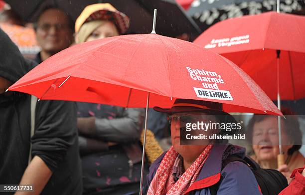 Parteianhänger der Partei DIE LINKE während der Wahlkampfabschlußveranstaltung auf dem Berliner Alexanderplatz, Frau unter einem roten Regenschirm