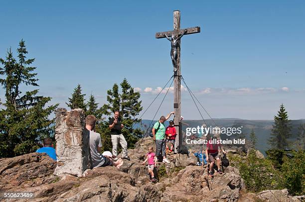 Bergwanderer am Gipfelkreuz des Großen Rachel bei Spiegelau im Nationalpark Bayerischer Wald. Mit 1453 Metern ist der Große Rachel der zweithöchste...