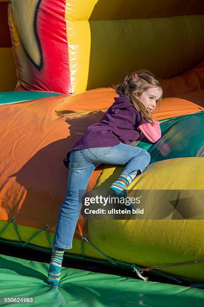 Auf einem Volksfest haben Kinder viel Spaß in einer Hüpfburg.