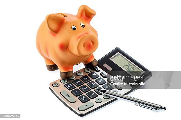 Ein roter Stift liegt auf einem Taschenrechner neben einem Sparschwein. Sparen bei Kosten, Ausgaben und Budget. Zinsen für Sparer