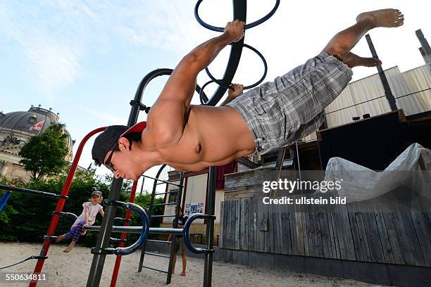 Jonny von der Sportgruppe Barserker präsentiert eine Übung auf einem Spielplatz im Monbijoupark in Berlin. Die Barserker verabreden sich über das...