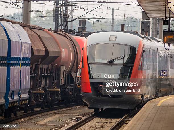 Wagon eines Güterzuges und die Lokomotive eines Personenzuges der ÖBB