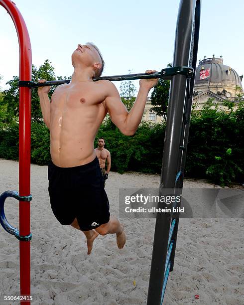 Anatoliy von der Sportgruppe "Barserker" präsentiert eine Übung auf einem Spielplatz im Monbijoupark in Berlin. Die Barserker verabreden sich über...