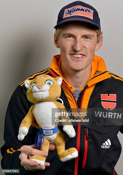 Skispringer Severin Freund posiert mit einem Maskottchen fuer die Olympischen Winterspiele 2014, waehrend der DSV Saisonpressekonferenz am 30....