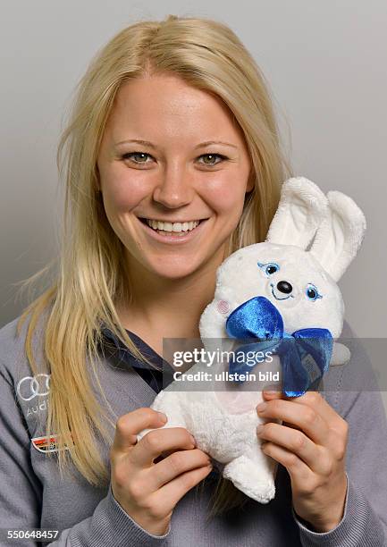 Biathletin Miriam Goessner posiert mit einem Maskottchen fuer die Olympischen Winterspiele 2014, waehrend der DSV Saisonpressekonferenz am 30....