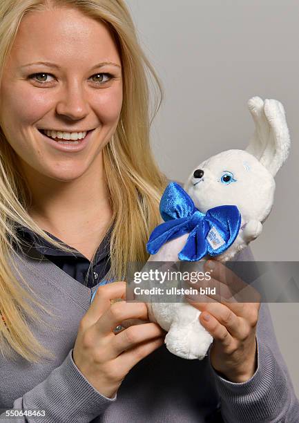 Biathletin Miriam Goessner posiert mit einem Maskottchen fuer die Olympischen Winterspiele 2014, waehrend der DSV Saisonpressekonferenz am 30....