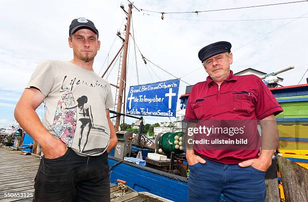 Sven-Eric Simbrich und Michael Hannig muessen " Daeumchen drehen " vor dem Fischkutter " SAS 73 Vereinigung " im Hafen Sassnitz auf der Insel Ruegen....