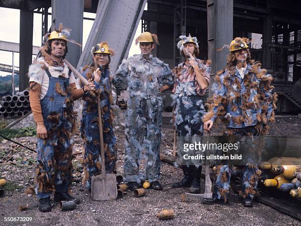 Monty Python's Flying Circus on a construction site with helmet and overall, tarred and feathered; from the l: Terry Jones, Michael Palin, John...