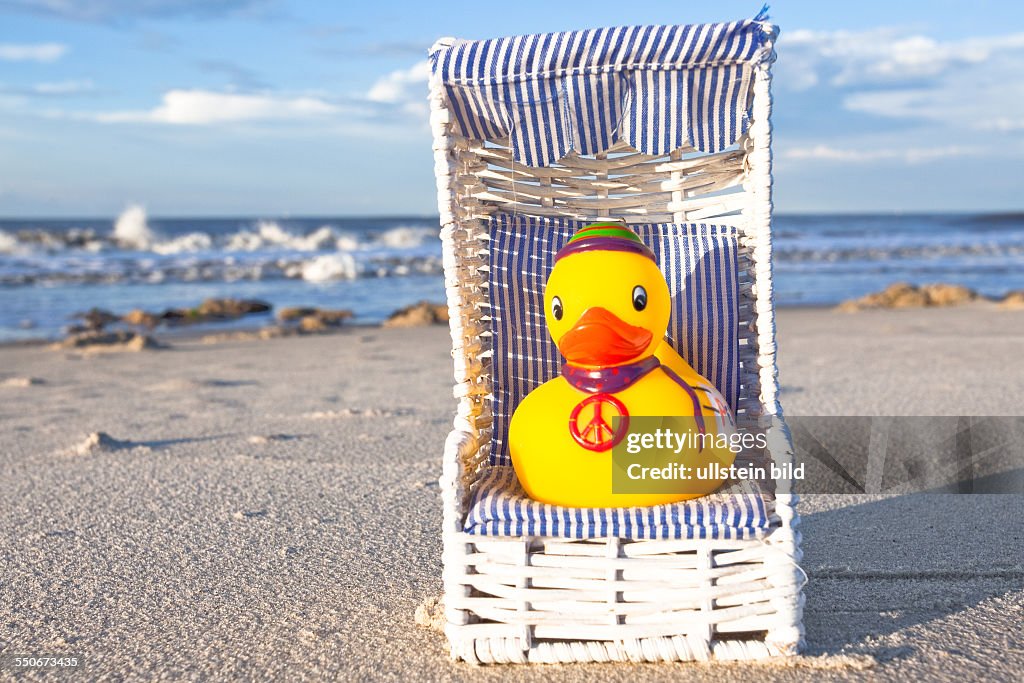 Yellow rubber duck, wearing a peace sign, Spiekeroog, North Sea coast, Lower Saxony, Germany.