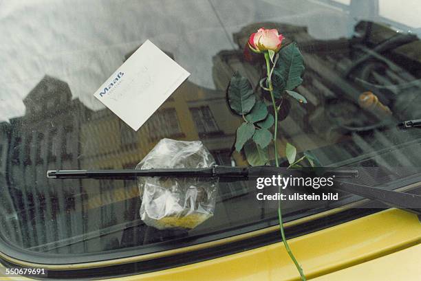 Grenzöffnung 1989 , Rose und Pralinen als Geschenk an DDR-Bürger an der Windschutzscheibe eines Autos in einer westdeutschen Stadt