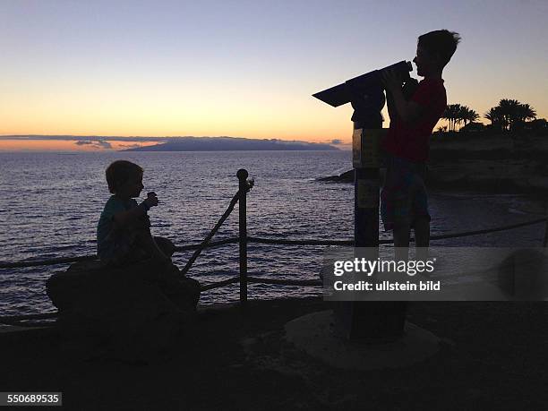 Spanien, Adeje, Tenerifffa, , Adeje, Teneriffa, Spanien, Kinder an einem Fernrohr, Blick zur Insel Gomera, im Abendrot, Sonnenuntergang