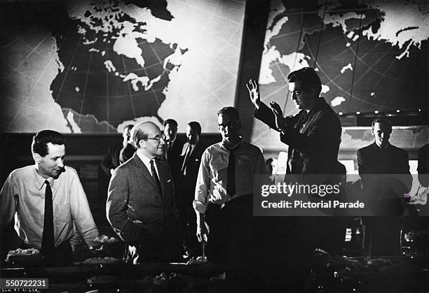 American director Stanley Kubrick directs British comic actor Peter Sellers on the Pentagon War Room set, during filming of the 1964 satirical...