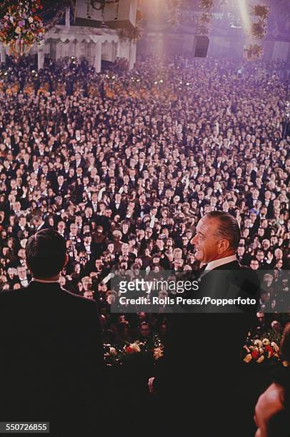 President of the United States, Lyndon B. Johnson pictured standing on a balcony during the Inaugural Ball at the Mayflower Hotel following Johnson's...