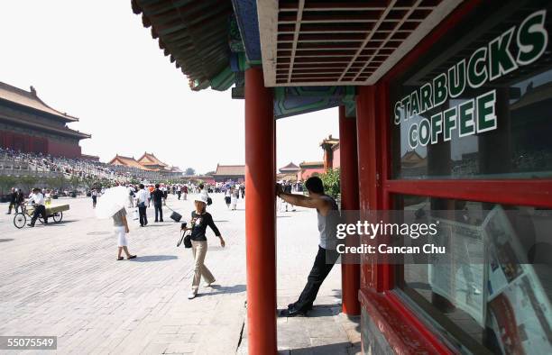 Visitor takes a break at Starbucks Coffee at the Forbidden City on September 6, 2005 in Beijing, China. Starbucks opened its Forbidden City shop in...