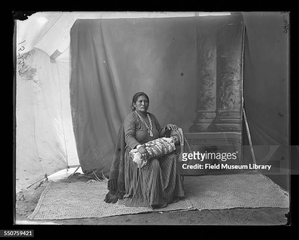 Portrait of Native American Navajo woman Mrs Vincinte Begay seated in a chair wearing a silver squashblossom necklace or jaclas coral and turquoise...