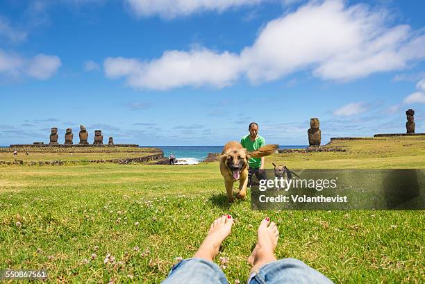 two people playing with dogs at rapa nui island - easter_island stock pictures, royalty-free photos & images