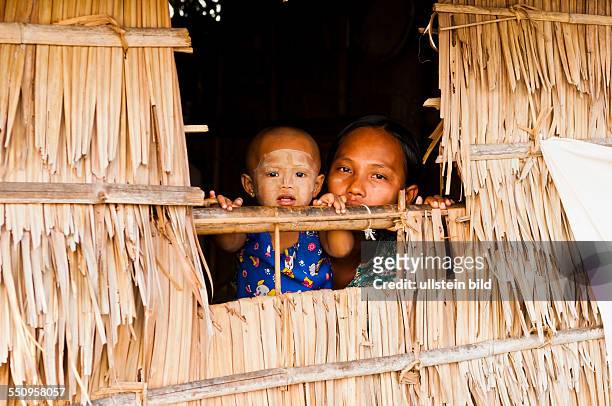 Das Dorf Tingangyi, Mutter und Kind schauen aus einer Huette