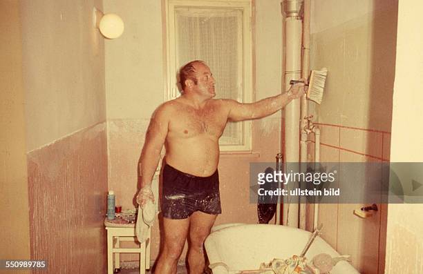 Ca.1968, Wohnungsrenovierung, Mann renoviert das Badezimmer