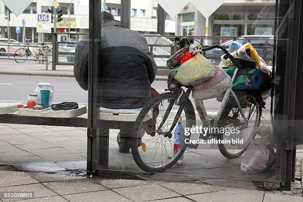 Berlin-Mitte: Armut in Deutschland - Obdachloser älterer Mann mit seinem Fahrrad und seinen Habseligkeiten an einer Bushaltestelle. Es gibt immer...