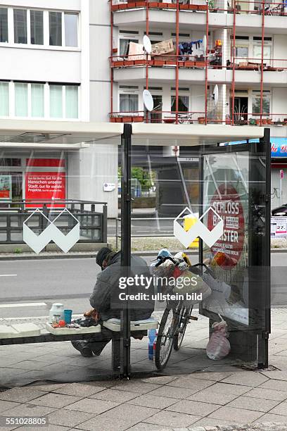 Berlin-Mitte: Armut in Deutschland - Obdachloser älterer Mann mit seinem Fahrrad und seinen Habseligkeiten an einer Bushaltestelle. Es gibt immer...