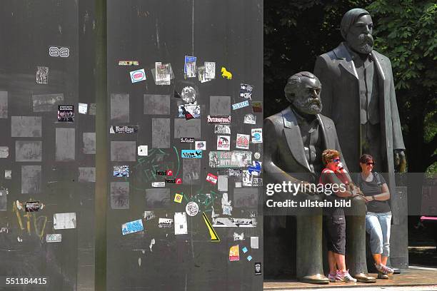 Denkmal fuer Marx und Engels an der Liebknechtstrasse, Fotomotiv fuer Touristen in den Goldenen Haenden von Marx. Aufkleber auf den Stahl-Stelen zur...
