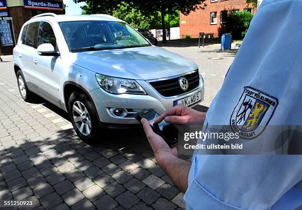 Ein Mitarbeiter des Ordnungsamtes Völklingen verteilt Strafzettel an falsch geparkte Autos, fotografiert.