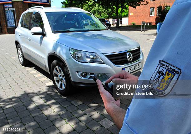 Ein Mitarbeiter des Ordnungsamtes Völklingen verteilt Strafzettel an falsch geparkte Autos, fotografiert.