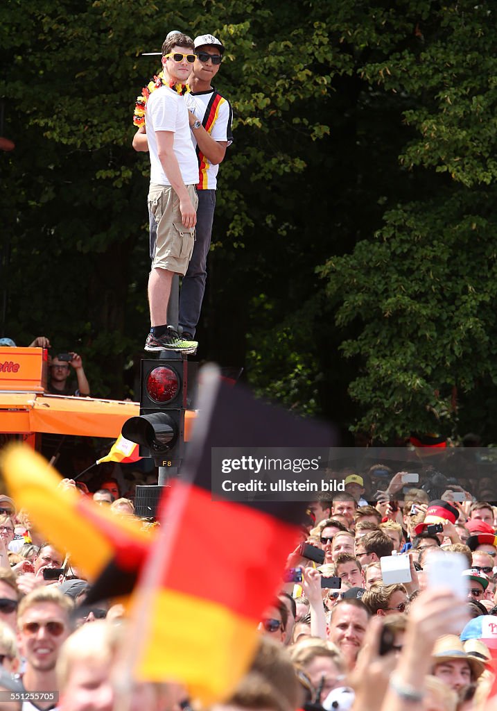Berlin-Mitte: Fanfest auf der Straße des 17. Juni vor dem Brandenburger Tor anlässlich der FIFA Fußball WM 2014 in Brasilien. - Empfang der Weltmeister - Zwei junge Männer stehen auf einer Ampel auf d