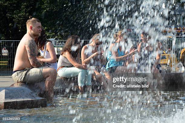 Berliner suchen Abkühlung an den Springbrunnenbecken auf dem Alexanderplatz in Berlin