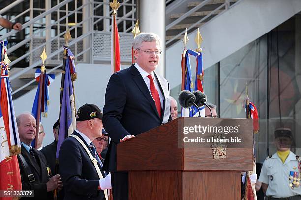 June 6 Courseulles, Normandy, France. Canada's prime minister is delivering his speech. Prince Charles, his wife Camilla, and the prime minister of...