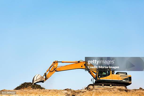 bulldozer on quarry against clear blue sky - construction equipment stock pictures, royalty-free photos & images